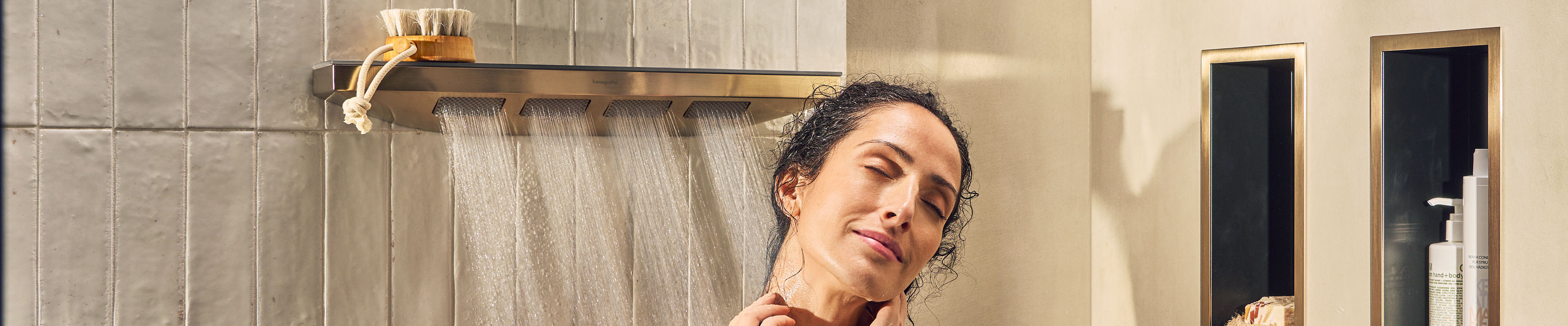 Woman enjoying the hansgrohe spray mode from her body spray.