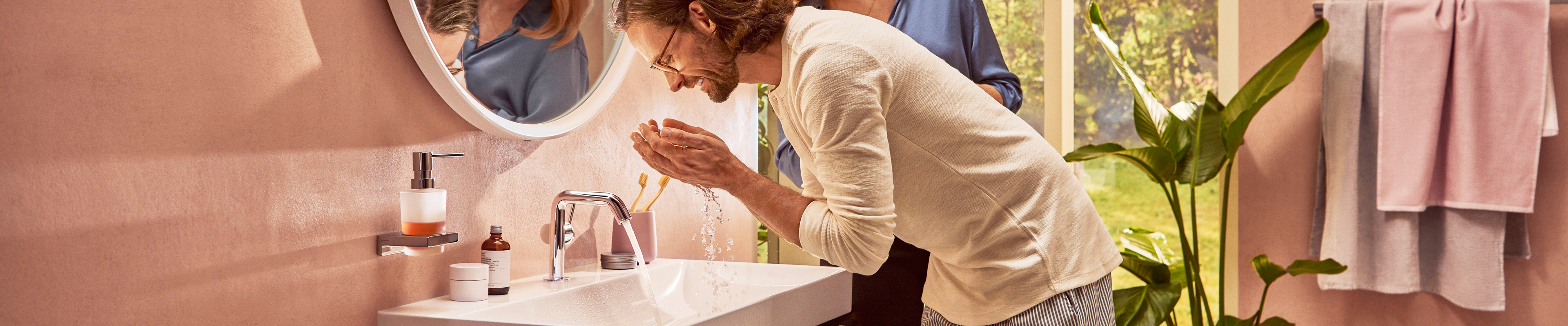 Man at the hansgrohe vanity with Tecturis S lavatory faucet.